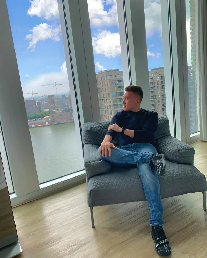 Arthur relaxing in an armchair by a floor-to-ceiling window