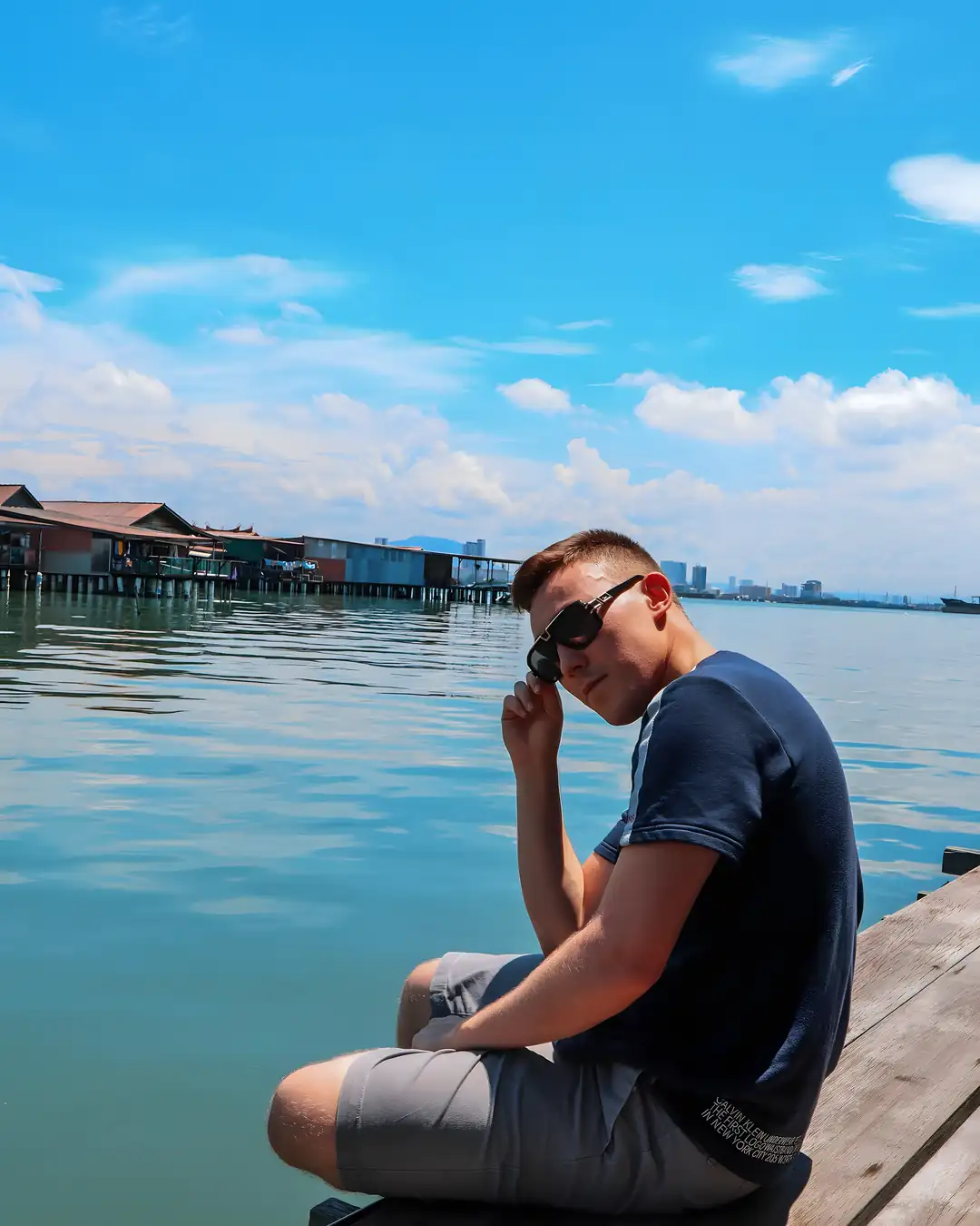 Arthur at the Penang waterfront, adjusting his sunglasses