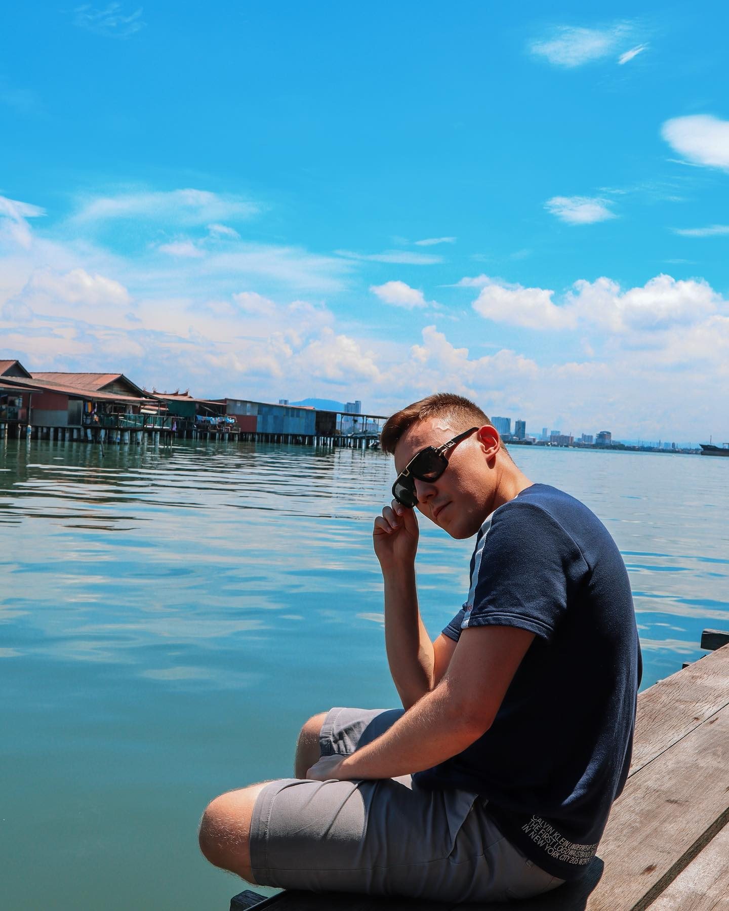Arthur at the Penang waterfront adjusting his sunglasses